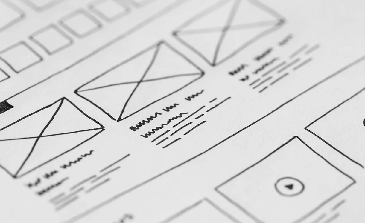 Hand-drawn website wireframes with image placeholders and lines of text